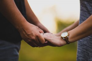 To personer holder i hånd for at signalere ro efter et familietjek